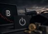 Laptop mit BitMart-Logo, sinkendem Kursverlauf und Kryptowährungen vor einem ausgeschalteten Symbol – Sinnbild für die schrittweise Einstellung des Börsenbetriebs.