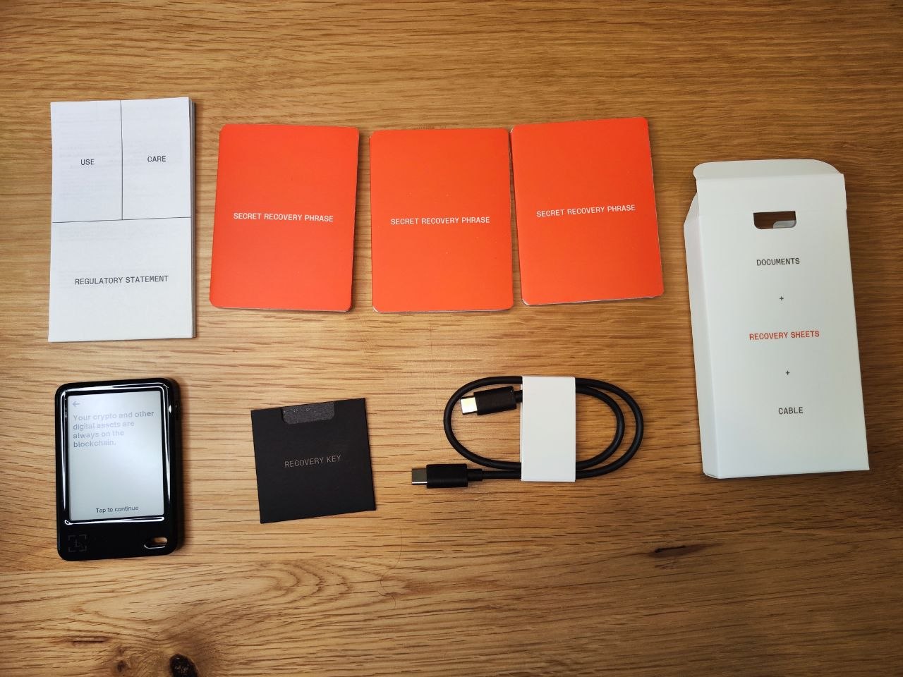 Lieferumfang des Ledger Nano 5 mit Hardware-Wallet, USB-C-Kabel, Recovery-Sheets und Dokumentation