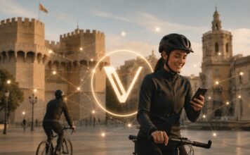 Radfahrerin in Valencia vor historischem Stadttor mit zentral eingeblendetem VeChain-Logo und digitalem Netzwerk.