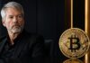 Michael Saylor neben einer goldenen Bitcoin-Münze. Die Münze steht scharf im Vordergrund, während der Manager nachdenklich zur Seite blickt und den Kontrast zwischen persönlichem Bitcoin-Besitz und Unternehmensstrategie symbolisiert.