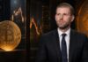 Eric Trump vor Bitcoin-Symbolen und Finanzcharts in einem Krypto-Interview-Setting