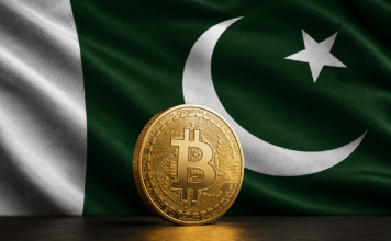 Goldene Bitcoin-Münze vor der grün-weißen Flagge Pakistans