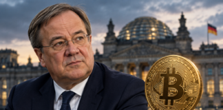 Armin Laschet neben einer goldenen Bitcoin-Münze vor dem Reichstagsgebäude.