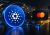 Cardano kooperiert mit Mastercard in Blockchain-Projekt Leuchtende Cardano-Münze vor digitaler Weltkarte und Mastercard-Karte als Symbolbild für Cardanos Einstieg in das Mastercard-Partnerprogramm.