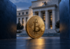 Goldene Bitcoin-Münze zwischen zwei dunkelblauen Wänden vor einem Gebäude im Stil der US-Notenbank.