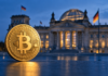 Krypto-Haltefrist: CDU-Geschäftsführer Schreiner will Abschaffung verhindern Goldene Bitcoin-Münze vor dem Reichstagsgebäude in Berlin als Symbolbild zur Debatte über die Krypto-Haltefrist.