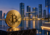 Goldene Bitcoin-Münze vor einer Skyline in Abu Dhabi mit blauem Coinbase-Symbol.