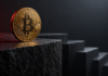 Bitcoin droht Liquidationskaskade: Mehr als 1 Milliarde Dollar an Longs in Gefahr Goldene Bitcoin-Münze am Rand einer dunklen Steinplatte vor absteigenden Stufen mit dezenter roter Beleuchtung.