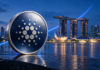 Cardano steigt 42 %: Dijkstra-Tests und Hoskinson-Keynote treiben den Kurs Symbolische Cardano-Münze vor dem Marina Bay Sands in Singapur mit einer aufwärts gerichteten blauen Lichtlinie.