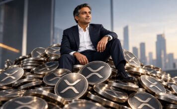 Größtes XRP-Treasury der Welt sichert sich Millionen für weitere XRP-Käufe CEO von Evernorth sitzt im Anzug auf einem riesigen Stapel von XRP-Münzen vor moderner Skyline – symbolische Darstellung eines wachsenden XRP-Treasurys.