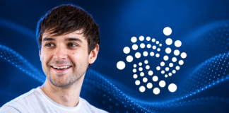Illustration von Dominik Schiener neben dem IOTA-Logo vor blauem Hintergrund