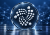IOTA-Logo auf einer gläsernen Scheibe vor blauem Hintergrund mit Netzwerkverbindungen.