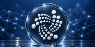 IOTA: Protokoll 37 ist live – diese Neuerungen bringt das Update IOTA-Logo auf einer gläsernen Scheibe vor blauem Hintergrund mit Netzwerkverbindungen.