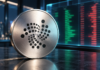 Silberne Münze mit IOTA-Logo vor einem stilisierten Orderbuch mit roten und grünen Handelspositionen.