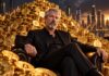 Michael Saylor sitzt vor einem riesigen Haufen goldener Bitcoin-Münzen, während im Hintergrund eine beleuchtete Skyline und steigende Kurscharts zu sehen sind.