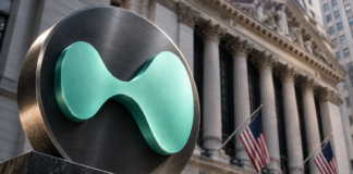 Türkisfarbenes Hyperliquid-Symbol vor der New Yorker Börse mit US-Flaggen.