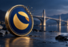 Terra Classic: Neue Burns treffen auf Millionenantrag für Cross-Chain-Brücke Blau-goldene Terra-Classic-Münze mit sich auflösender Kante und einer Brücke im Hintergrund.