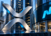 Silbernes XRP-Symbol vor einer modernen Glasfassade mit blauem Nasdaq-Logo